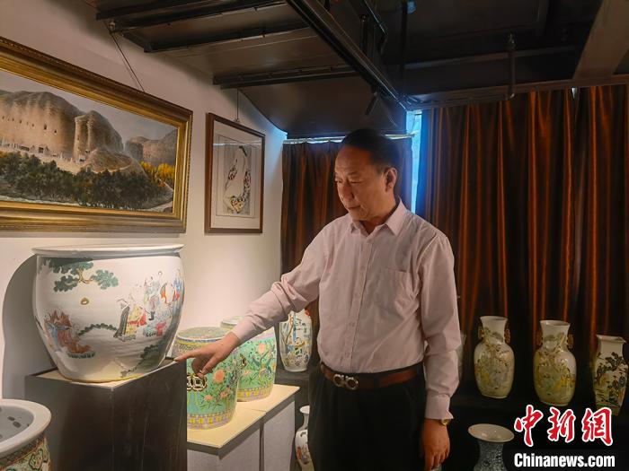 劉世杰向記者介紹自己收藏的文物?！「呖档?攝